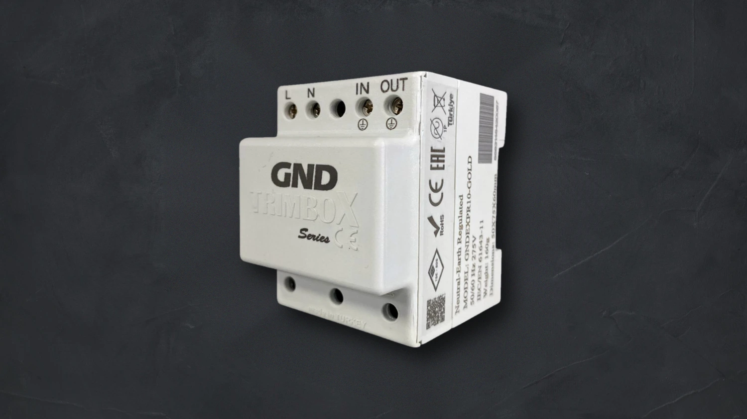 Trimbox GND series DIN-rail module — white housing with L, N, IN and OUT terminals, on a dark background